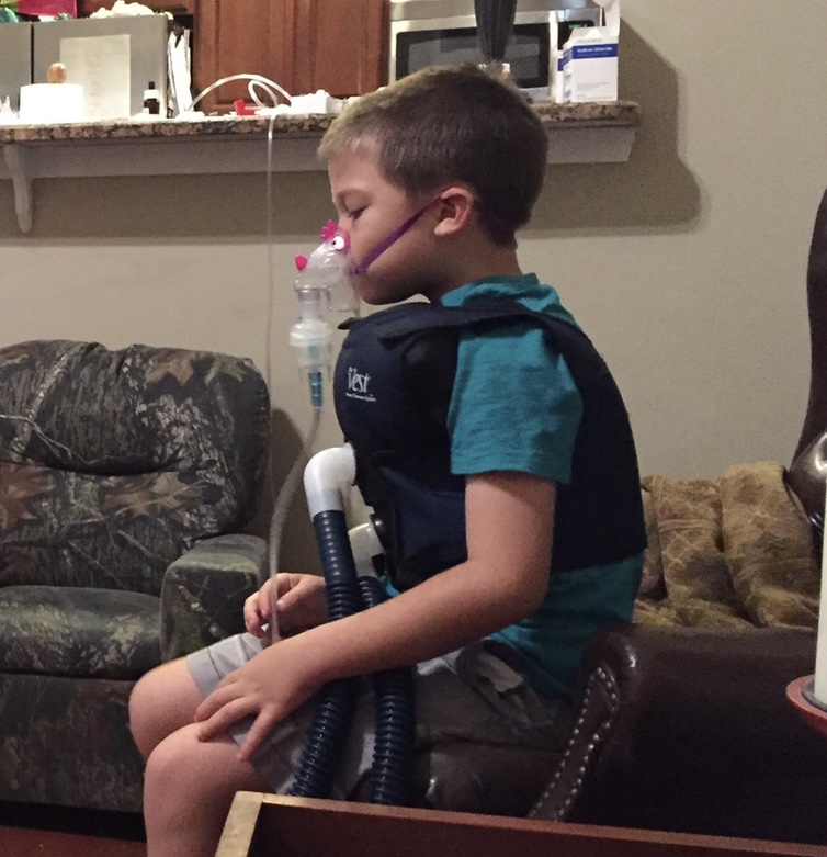 A boy with a medical vest and oxygen