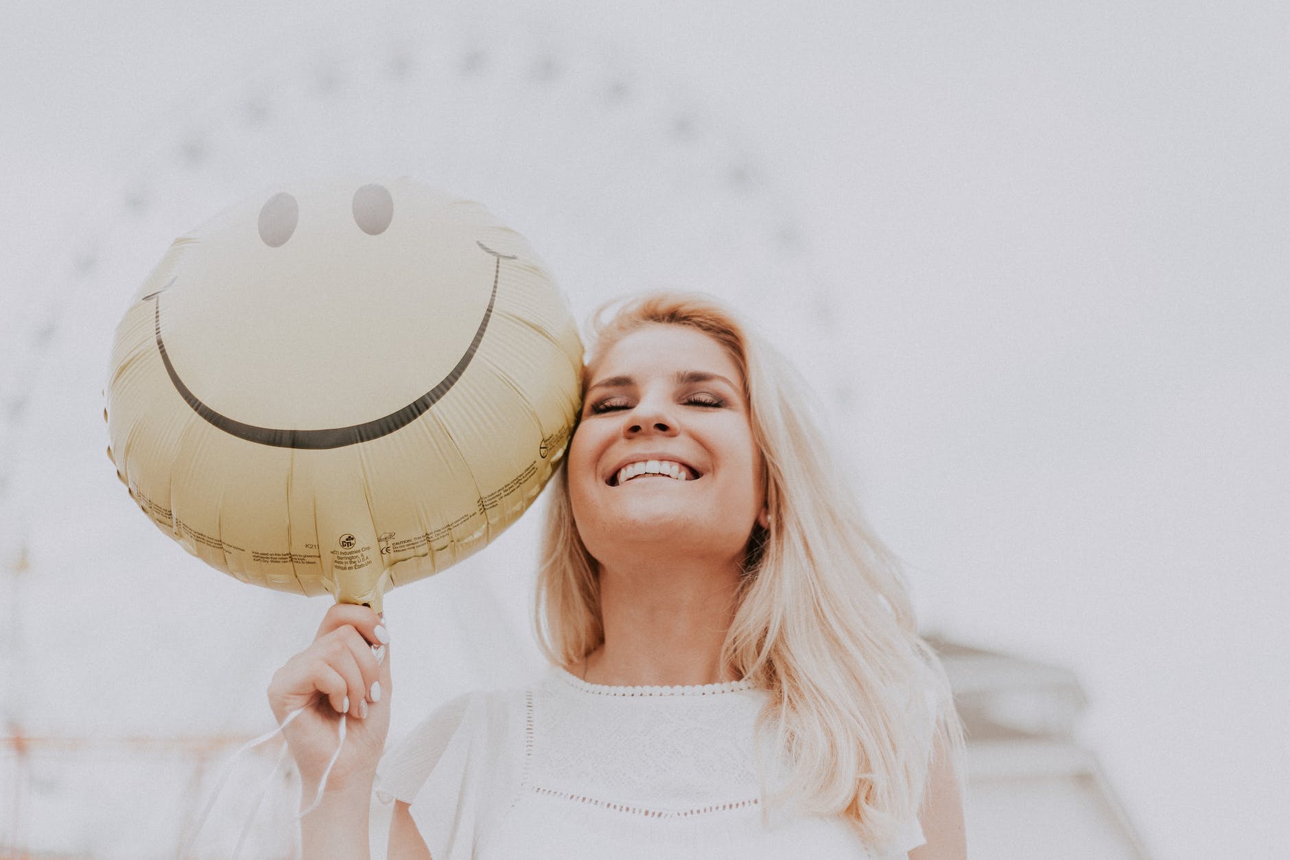 woman in a good mood; woman holding a smiley balloon