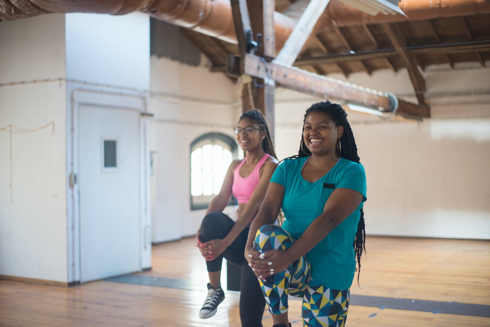 smiling women stretching their legs